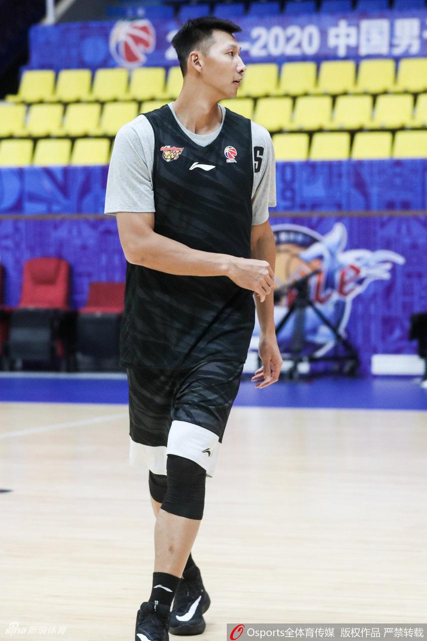 易建联运球突破防守队员,动作舒展流畅,眼神锐利地观察着场上队友的跑位情况