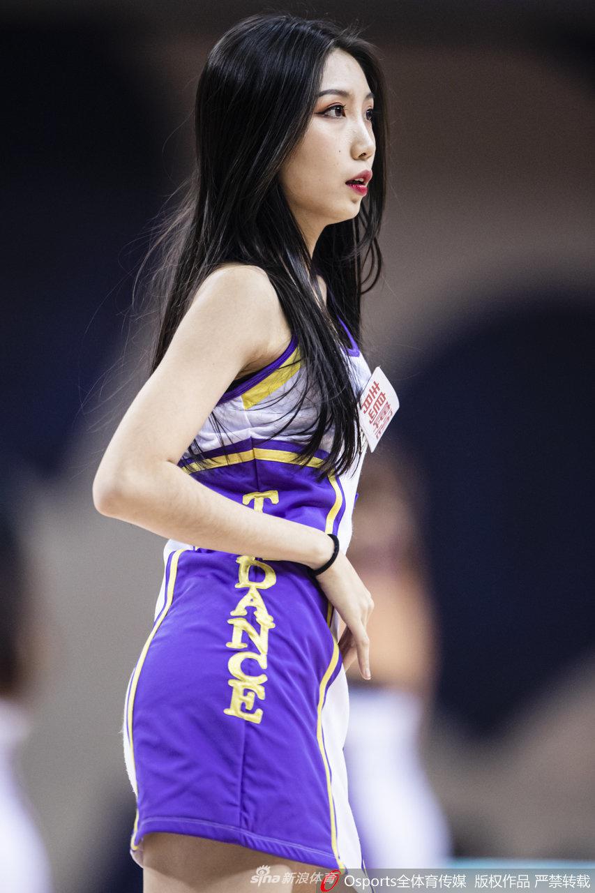 队员们在场上排成纵列，手中的花球随着动作上下翻飞，仿佛紫色的火焰在球场燃烧