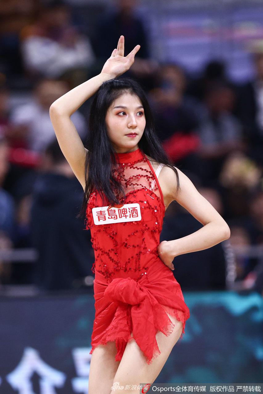 一位篮球宝贝在表演中做出高难度的侧身一字马动作，展现出了极佳的身体柔韧性与专业素养，赢得观众席阵阵喝彩