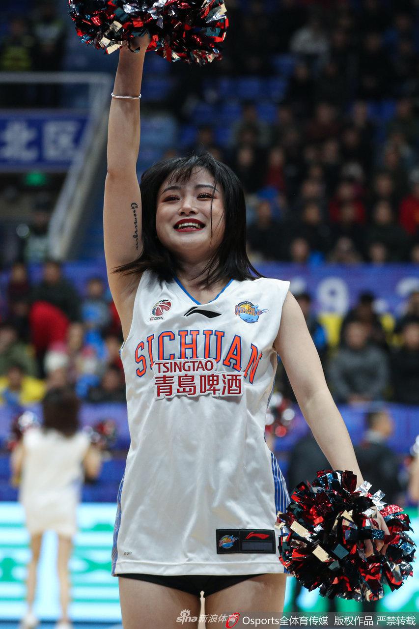 一位篮球宝贝在聚光灯下完成高难度动作，她专注的眼神和舒展的身姿，彰显了平日刻苦训练的成果，也打破了人们对拉拉队员“花瓶”的刻板印象。