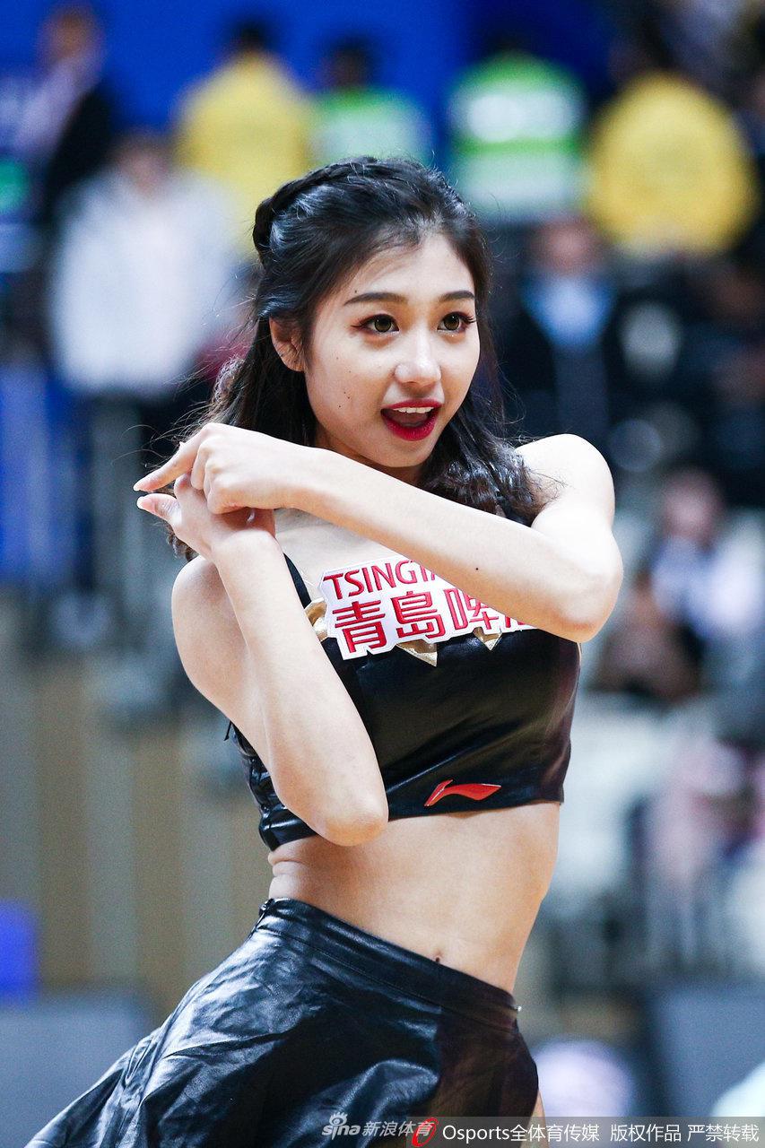 一名啦啦队宝贝在热舞中回眸一笑，甜美的酒窝和灵动的眼神极具感染力，让紧张激烈的比赛氛围多了一份轻松与愉悦。