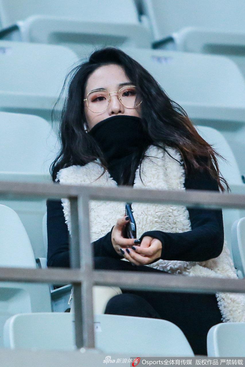 美女球迷手拿饮料,眼神中带着一丝期待,仿佛在期盼主队下一轮比赛能有更精彩的表现。