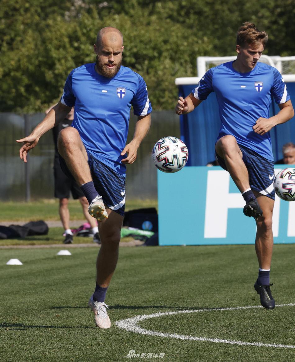 一名芬兰球员正在进行拉伸训练，他的身影倒映在绿色的草皮上，每一个细节的准备，都是为了在场上多跑一步，多争一次机会。