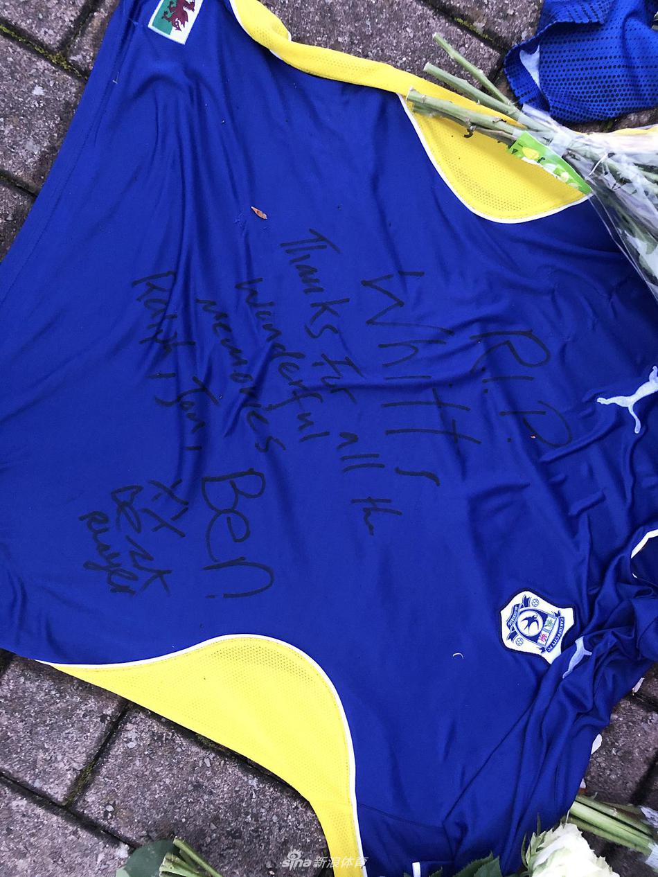 一位头发花白的老球迷，深情地抚摸着一件裱框好的惠廷汉姆签名球衣，他的眼神中充满了不舍与怀念，仿佛正透过这件球衣，与过去那些激动人心的比赛时光对话。