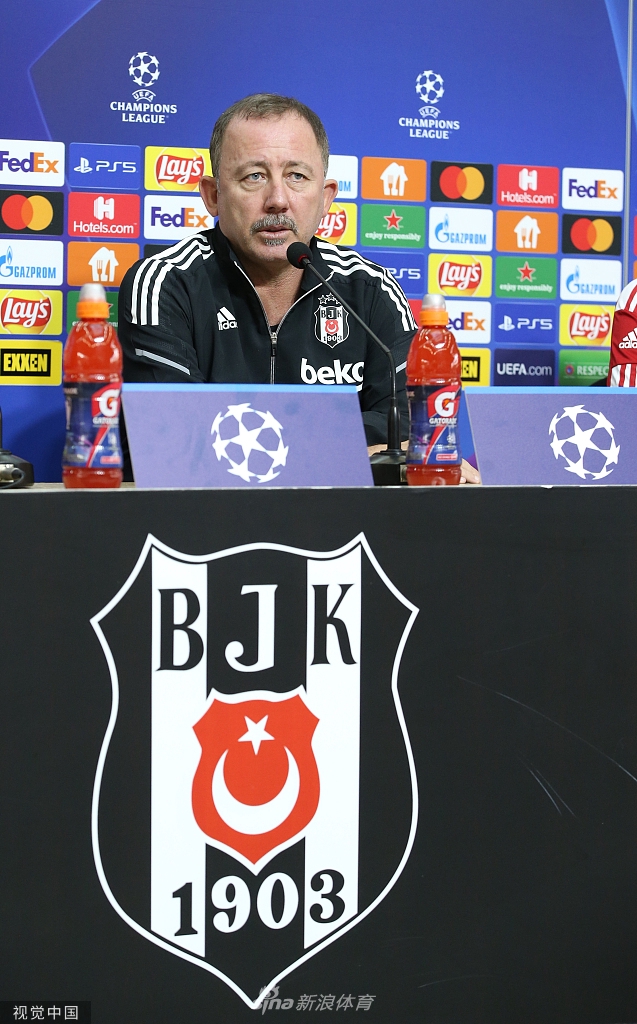 发布会结束后，球员独自穿过光线略显昏暗的球员通道。巨大的黑色影子被拉长在身后，与他坚毅的步伐形成鲜明对比。他低头调整着手腕上的队长袖标，即将走出阴影，踏入那片被灯光照亮、属于他的战场，整个通道都弥漫着决战前的肃穆气息。