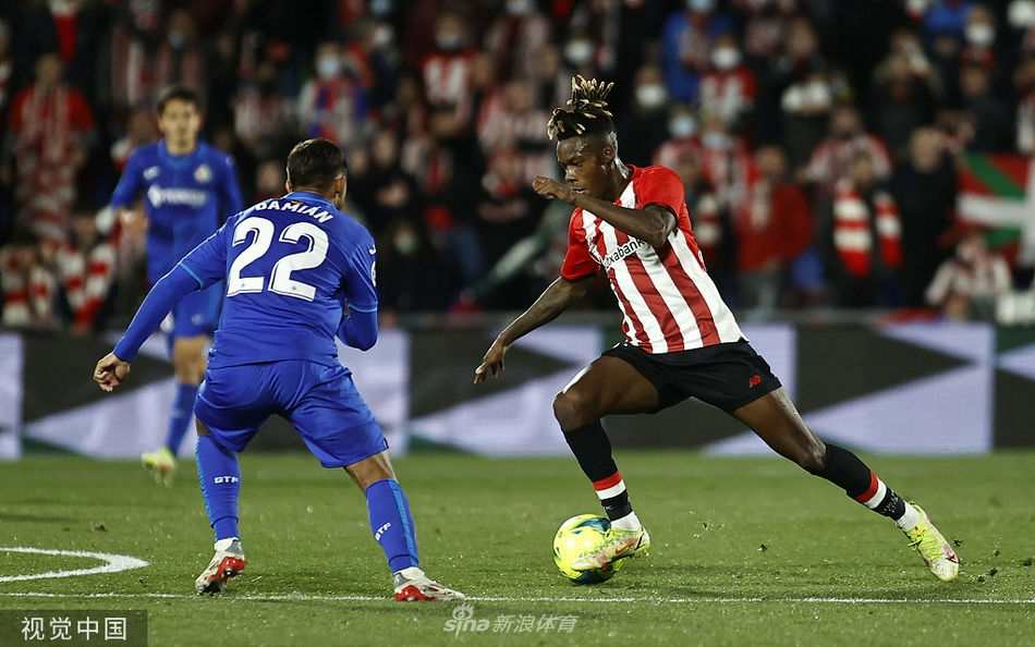 赫塔菲前锋于纳尔在毕尔巴鄂竞技禁区内，与对方后卫伊尼戈·马丁内斯展开激烈的空中争顶，两人肌肉紧绷，展现了纯正的力量对抗。