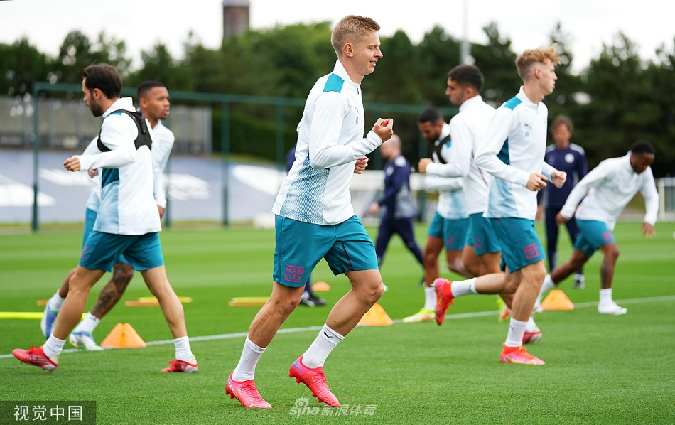 训练结束，一名曼城球员扛着一整袋训练用球走向球场边，夕阳将他离去的背影拉得很长，这份默默的付出与汗水，正是为了夜晚聚光灯下的荣耀绽放。