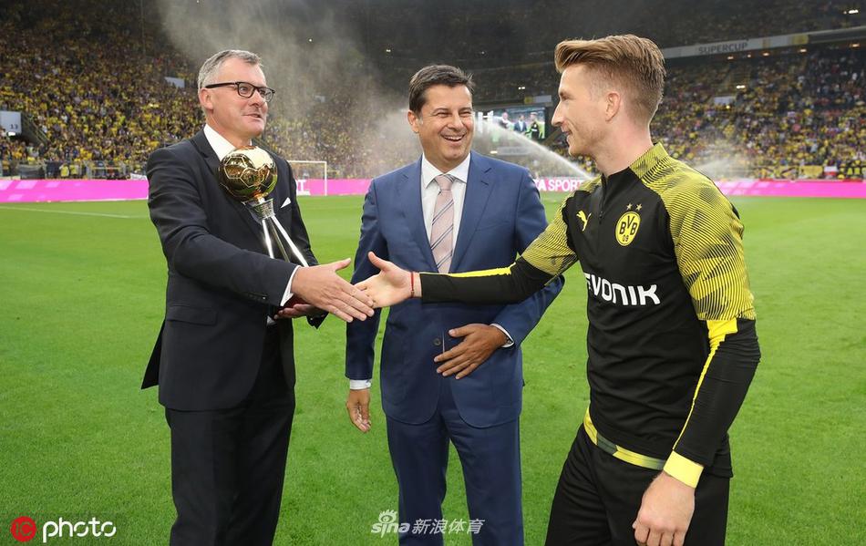 罗伊斯与德国足球先生奖杯合影，他面带微笑，亲吻着奖杯，仿佛在诉说着回归之路的艰辛与喜悦。