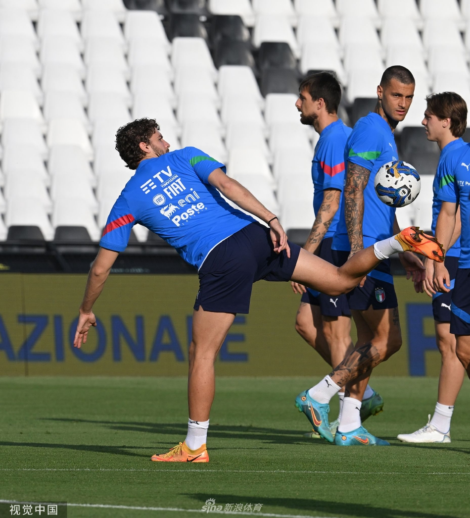 曼奇尼在新闻发布会上手持话筒，神情专注而严肃，正在向媒体阐述球队重建的计划，背景是布满赞助商标识的发布会背板。