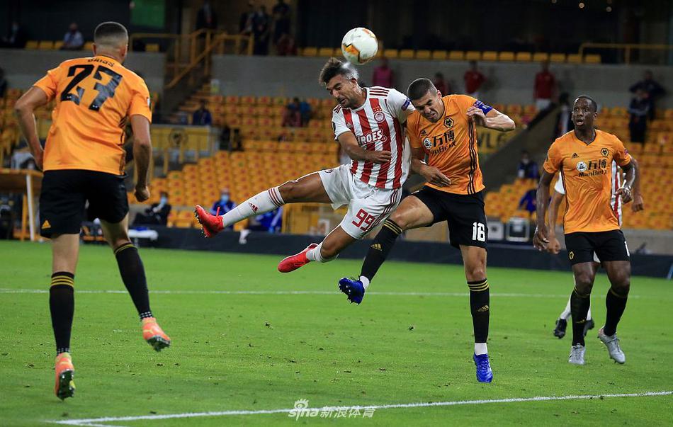 狼队队长考迪贴身紧逼奥林匹亚科斯高中锋阿拉比，两人手臂交织肌肉紧绷，在空中争顶的瞬间仿佛时间凝固