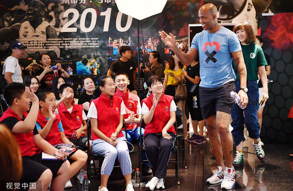 孩子们兴奋地将马布里围在中间,他们正在‘马布里之家’的展柜前进行一场别开生面的运球游戏,马布里张开双臂试图防守,现场充满了欢声笑语。