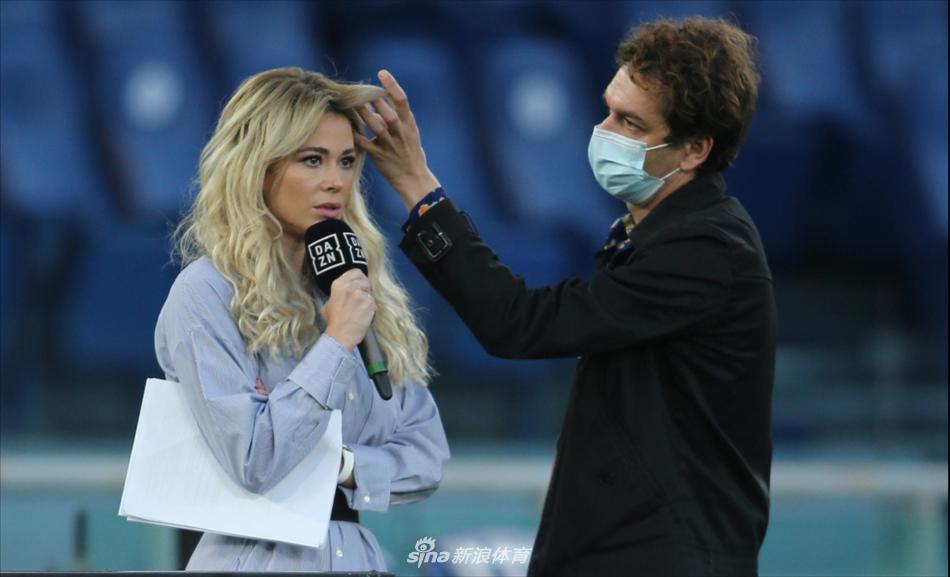 阳光洒在罗马奥林匹克球场的草坪上，美女主播迪莱塔-莱奥塔手持话筒，回眸一笑，金色的发丝在光影中闪耀。