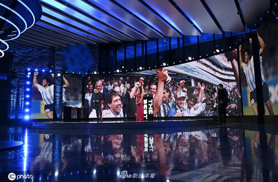 那不勒斯的夜空被蓝色的焰火照亮，球迷们自发聚集在圣保罗球场外，高举着印有“10”号和马拉多纳头像的围巾与旗帜，仿佛他从未离开，永远守护着这座他深爱的城市。