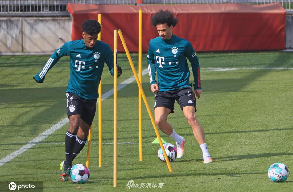 训练场上出现温情一幕，王牌前锋莱万多夫斯基与队友格雷茨卡并肩慢跑调整呼吸，两人面带微笑交流着训练心得，身后是绿茵场上巨大的拜仁队徽，仿佛预示着他们正肩负着俱乐部的荣耀前行。