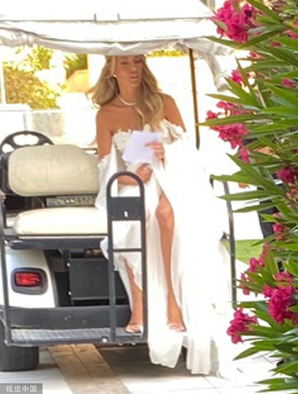 全家福合影。莫拉蒂夫妇并肩而立，两个可爱的孩子站在父母身前，男孩身着迷你西装，女孩穿着白色小纱裙，一家人面对镜头展露幸福笑容，背景是威尼斯水城的典型街景。