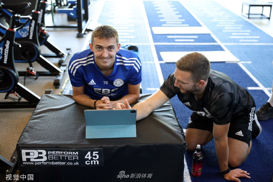 球员在健身房内进行力量训练，汗水淋漓展现出拼搏精神。