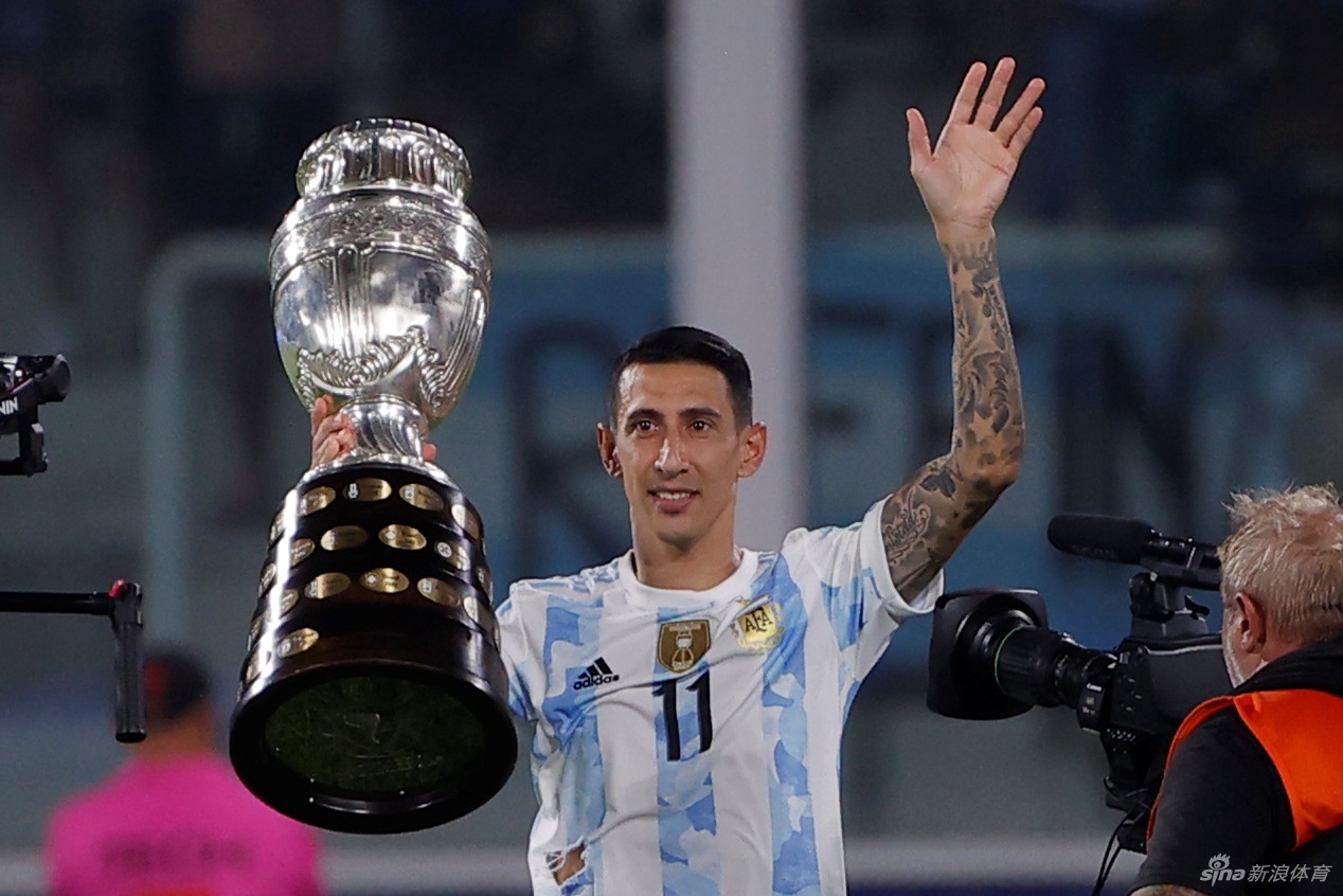 阿根廷队主教练斯卡洛尼站在场边，神情专注，紧握双拳指挥着场上球员