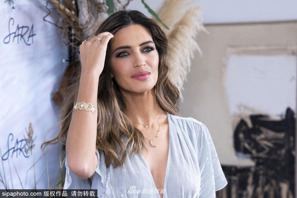 萨拉·卡波内罗轻撩秀发，眼神中透露出经历风雨后的从容与坚定，尽显成熟魅力。