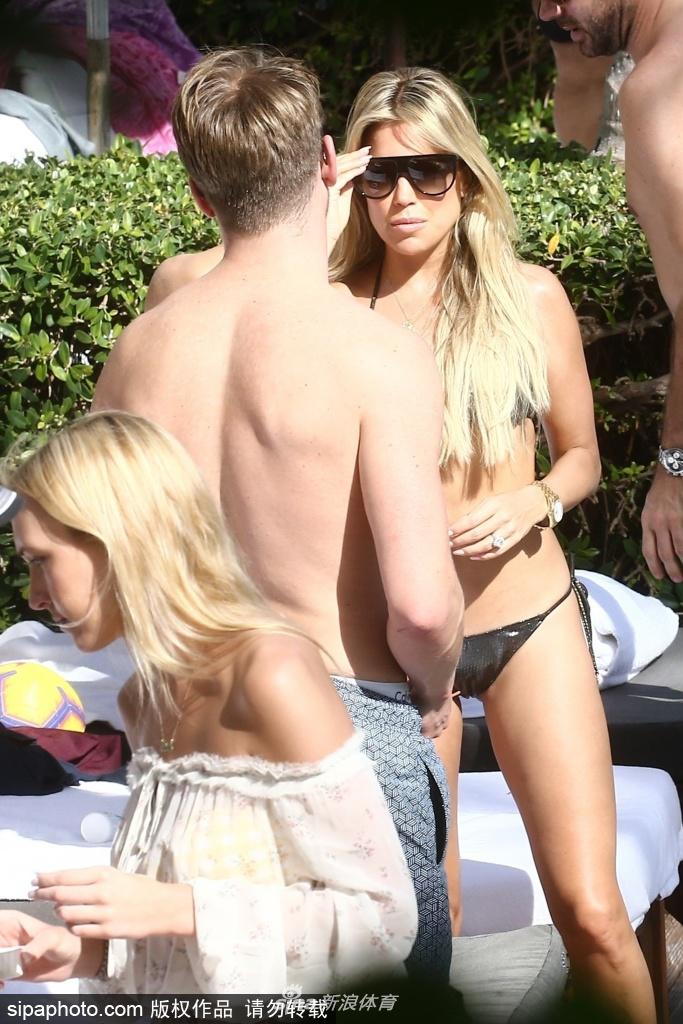 西尔维趴在泳池边，回眸对着镜头俏皮一笑，身后是迈阿密湛蓝的天空和棕榈树