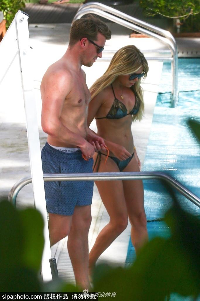 西尔维戴着宽檐草帽，身穿白色镂空长裙漫步街头，男友紧随其后，目光始终停留在她身上