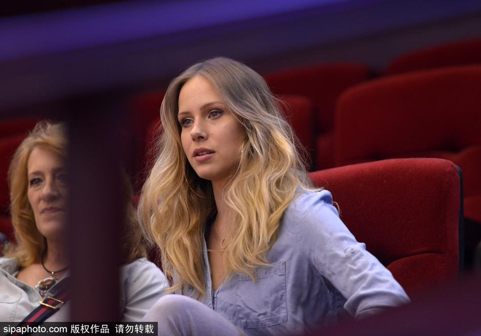 金发碧眼的宝莲娜身着一袭休闲装，坐在山东高速主场看台上，目光紧紧锁定场上的丈夫，嘴角洋溢着自豪而甜蜜的微笑。