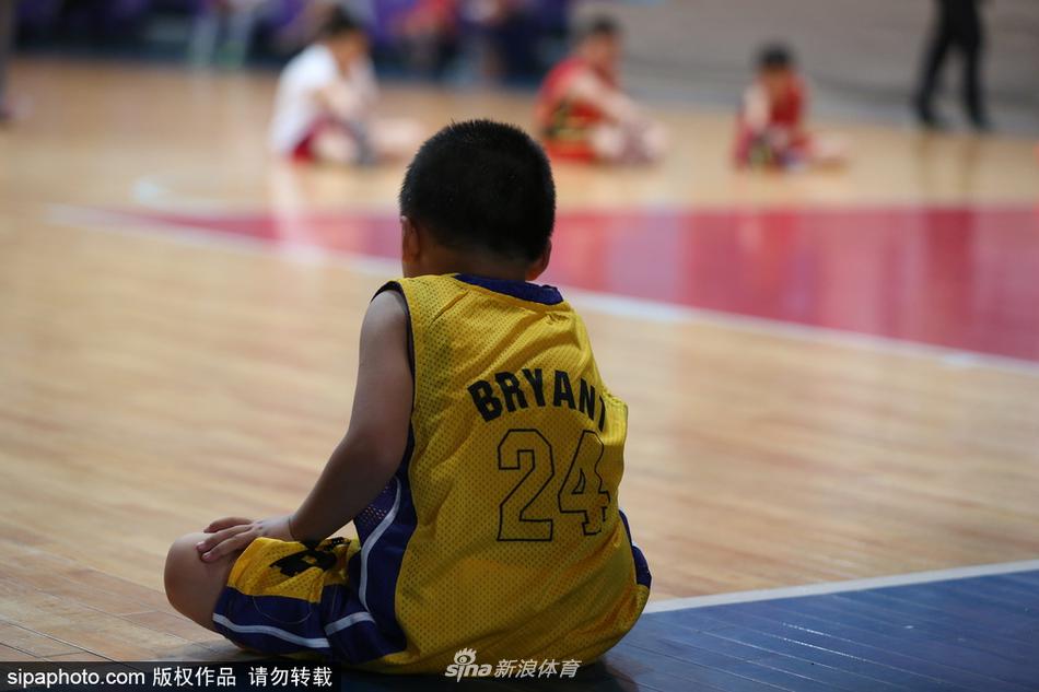 辽宁工程技术大学篮球学院的课堂上,教授正为学生讲解战术板上的跑位,窗外是正在热身的校队球员。