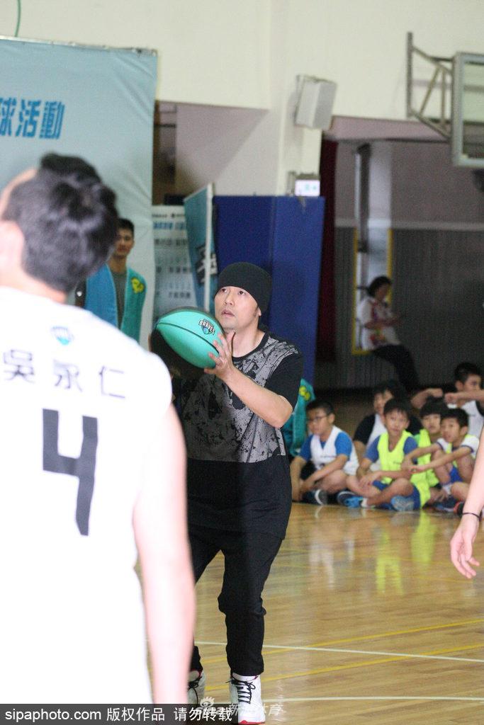 活动接近尾声，周杰伦站在场地中央与几十名身穿蓝色球衣的孩子们合影，他依然戴着那条标志性的黑色头巾，双手插腰，被孩子们簇拥着，画面定格在这个充满爱心与活力的夏日午后。