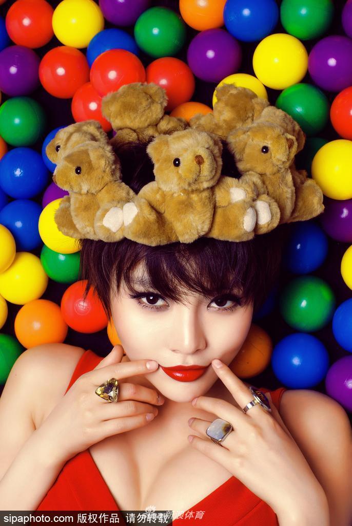 她侧身而坐,双腿盘起将篮球轻轻放在膝上,目光温柔地望向远方,宛如球场边的一幅静态油画