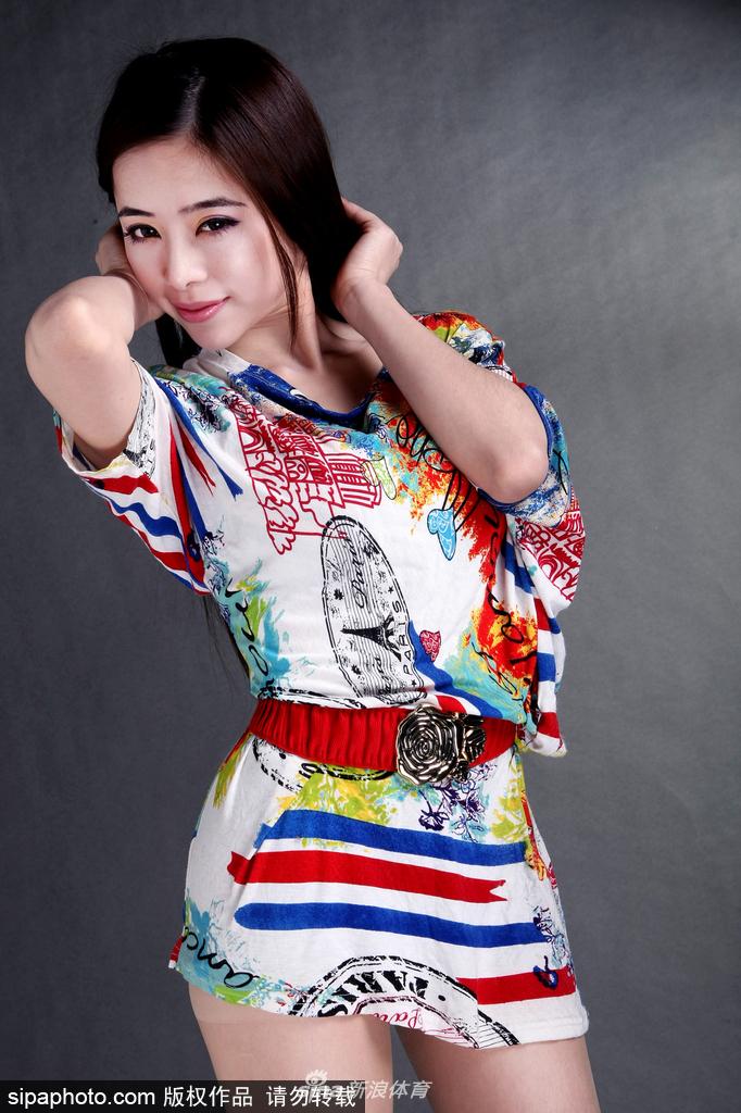 光线透过铁丝网洒在袁颖芬身上，她单手扶着围网，神情淡然却气场十足，完美融合了力量与柔美