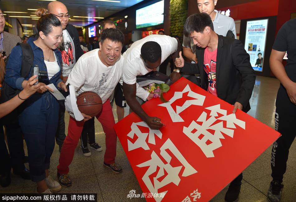 机场大厅内,巴斯一边拖着行李前行,一边不忘回头与身旁的球迷挥手致意,举手投足间尽显亲和力。