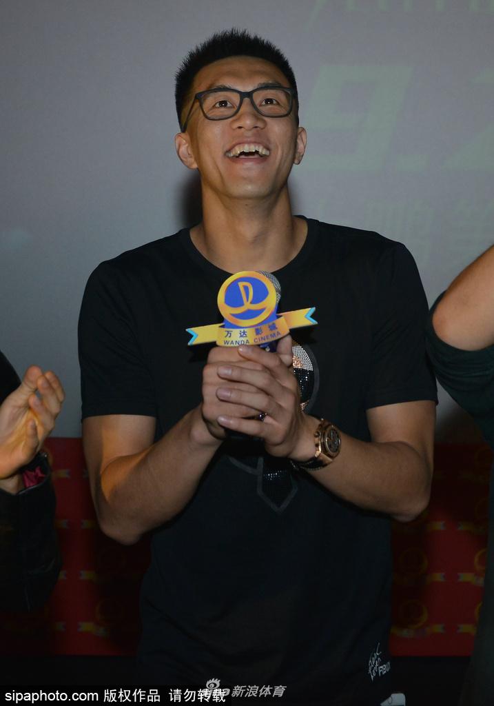 大鹏在台上拿着话筒讲话，身后的乔杉、李鸿其、曲隽希等主演一字排开，背景板上写着缝纫机乐队东北首映礼大字