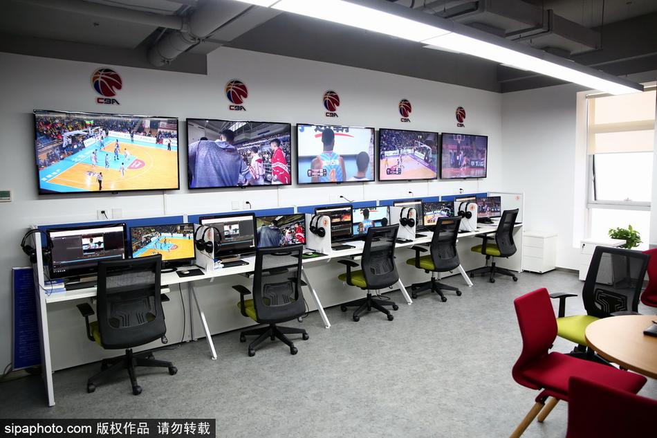 一名工作人员正在调试复杂的音频通讯设备,确保回放中心与各个赛场之间的沟通线路畅通无阻。