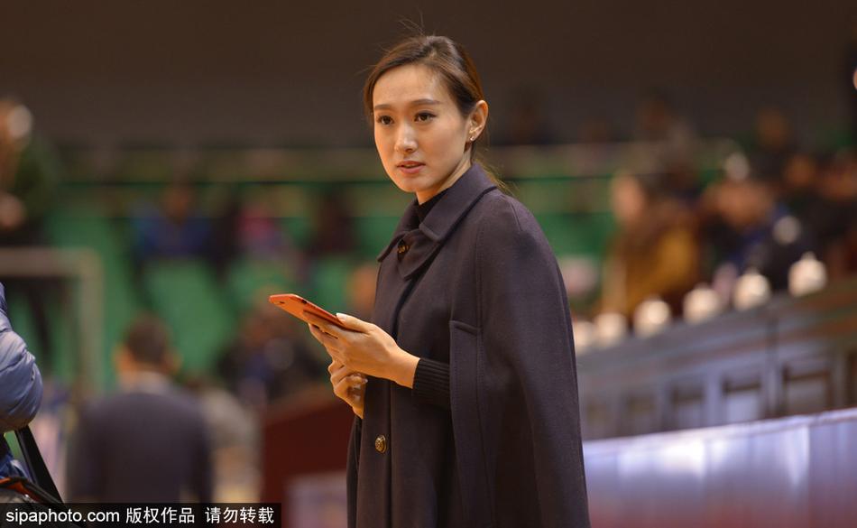 全景镜头扫过座无虚席的山东高速球馆，一名长发披肩、妆容精致的美女球迷恰好在人群中抬头，清澈的眼眸中倒映着球场上的光芒，仿佛在与场上球员进行无声的对话。