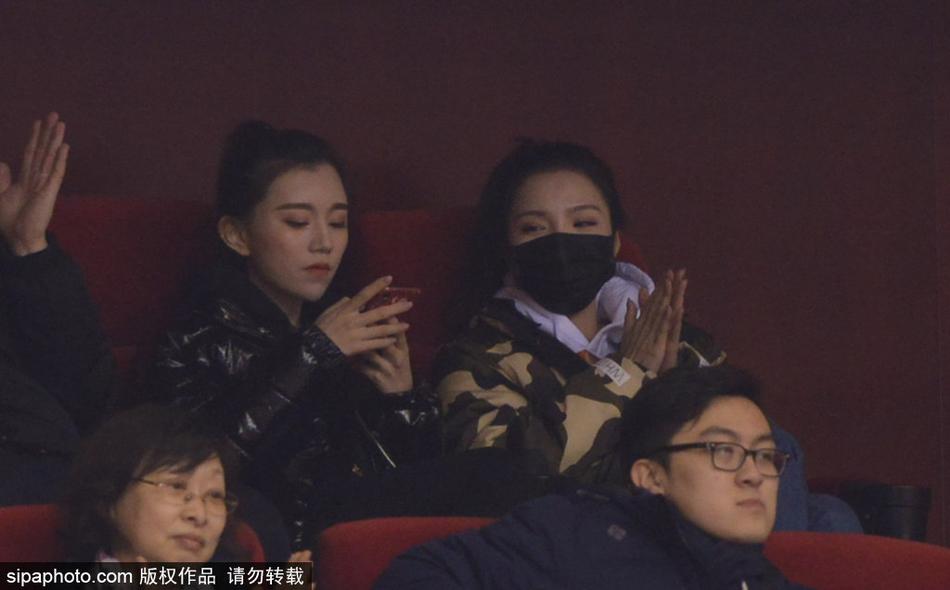 暖黄的灯光洒在睢冉妻子优雅的微笑上，她与身旁的丁彦雨航女友组成最美看台组合，两人轻松的神情似乎预示着场上山东队即将吹响胜利的号角。