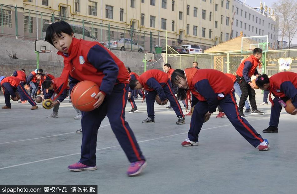 冬日的暖阳洒满校园,近千名小学生整齐列队,他们手中的橙色篮球仿佛跳动的火焰,瞬间点燃了整个操场的热情。