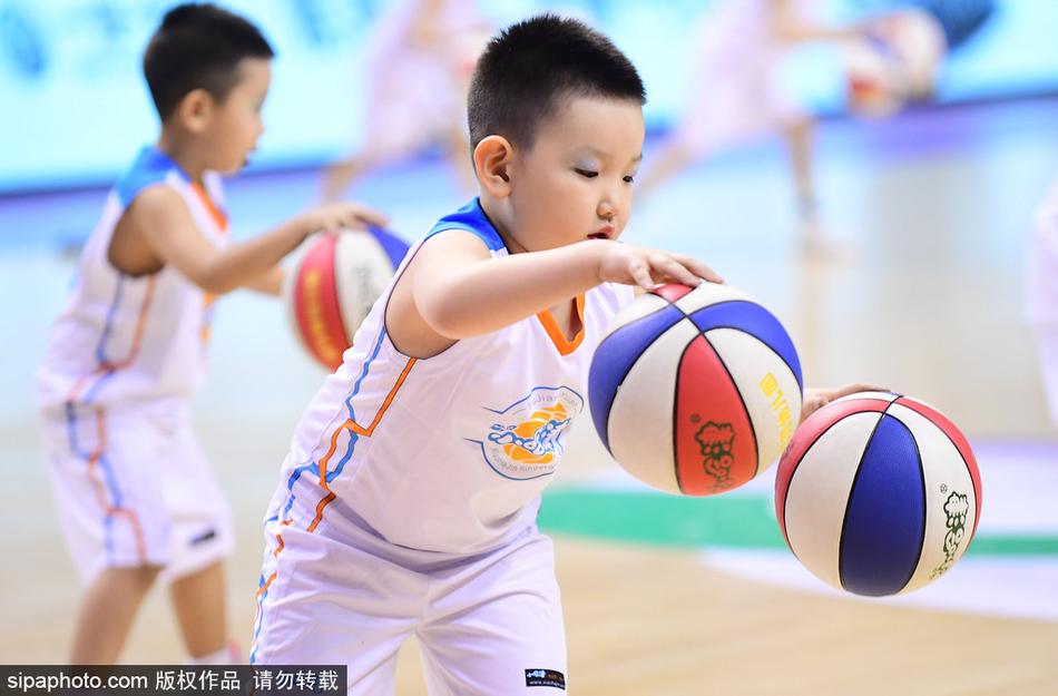 镜头拉近,一位领舞的小男孩双手同时运球,表情酷酷的,仿佛在告诉全世界:未来篮球巨星就是我!身后的队友们则排着整齐的队形为他加油。