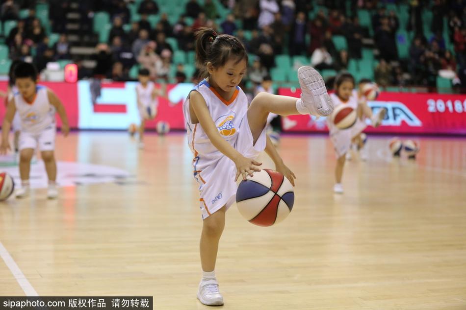 一群穿着红色篮球服的小朋友们在CBA赛场中央认真拍球,圆滚滚的篮球在他们小手中听话地上下跳动,眼神专注又可爱。