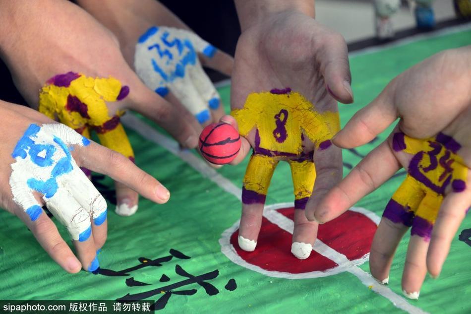 几双不同肤色的手交织在迷你球场上空,指尖上分别涂着红蓝两色。一颗小小的纸团篮球正从一根手指尖被挑起,即将飞向不远处的‘篮筐’,对手的‘防守球员’正试图拦截,画面定格在攻防转换的紧张瞬间。