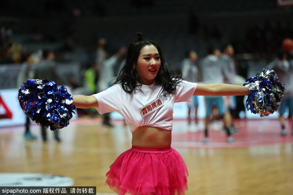 一位篮球宝贝正在赛场中央尽情热舞，她张开双臂，身姿舒展，仿佛一只翩翩起舞的蝴蝶，全情投入地享受着这个属于她的舞台。