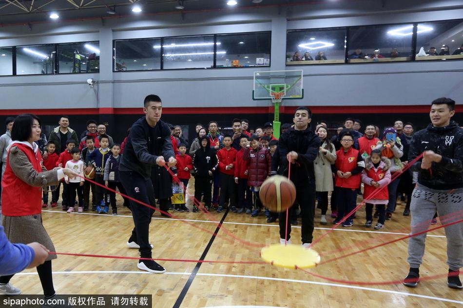 王中光指导被热情的球迷层层围住,他低头仔细辨认着球迷递来的每一件纪念品,眼神专注而亲切。