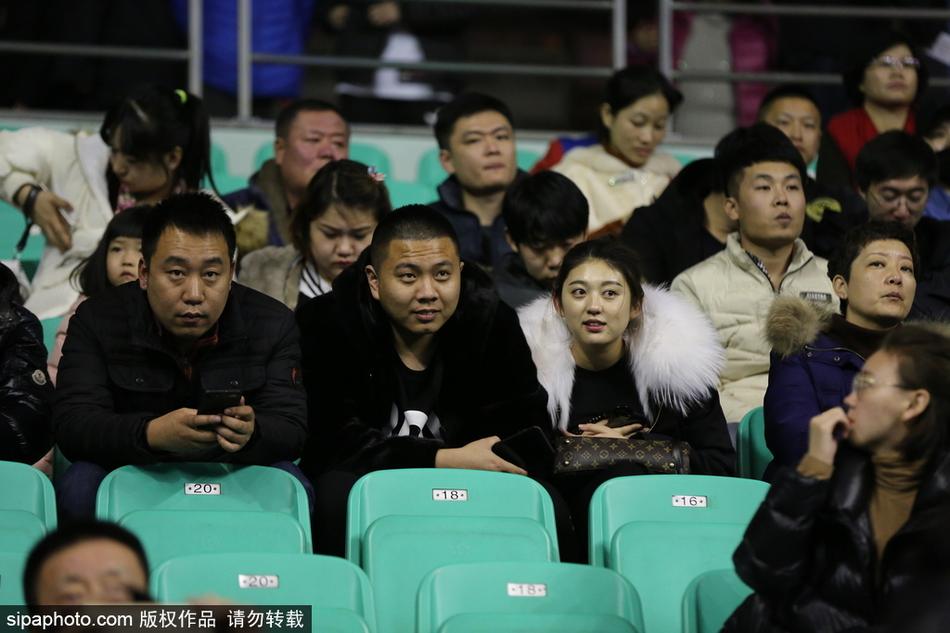 几位球迷在体育馆通道内合影留念，他们身上的貂绒大衣各不相同，但脸上都带着同样满足而自豪的微笑，为这场精彩的胜利留下永恒的瞬间。