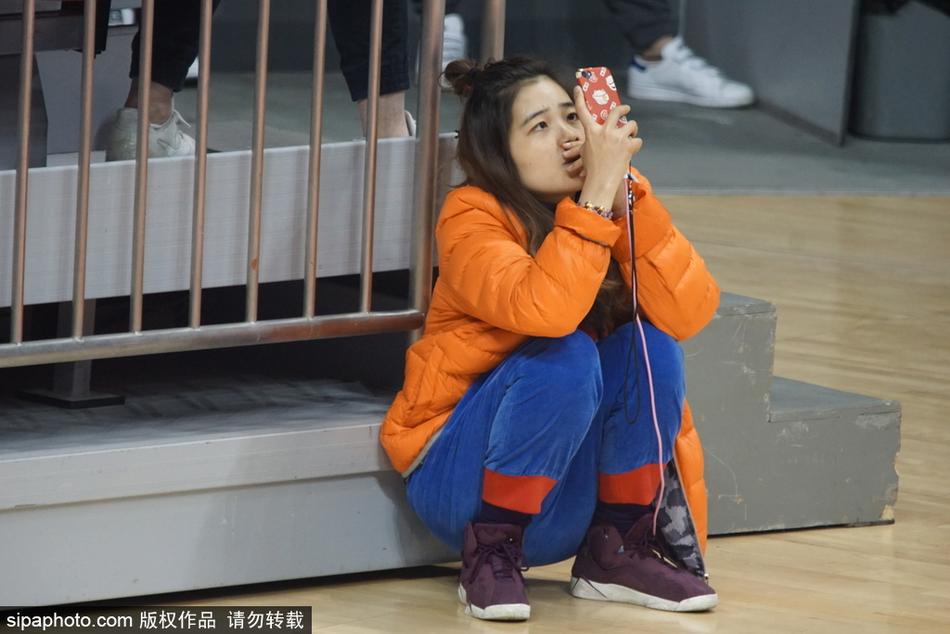 这位美女观众在人群中微微侧头,嘴角带着一丝若有若无的微笑,仿佛是看到了场上某个有趣的回合,这种自然的瞬间流露,比刻意摆拍更显动人。