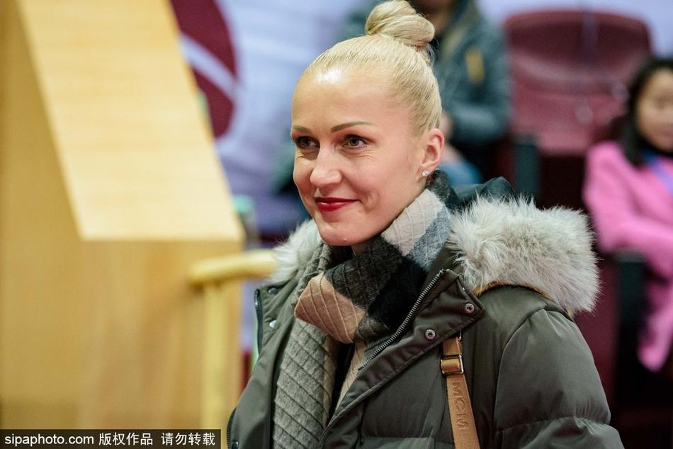 比赛尘埃落定，四川女篮外援起身准备离场，脸上带着满意的神情。她们身后的记分牌显示着四川队122比105的胜利比分，仿佛在诉说一场精彩的跨界助威故事。