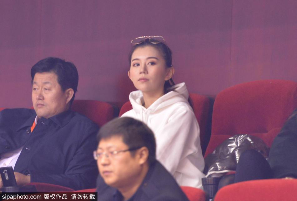 一位为青岛队加油的美女球迷,她的神情专注而略带紧张,在这场齐鲁德比中,她与场上球员同呼吸共命运。