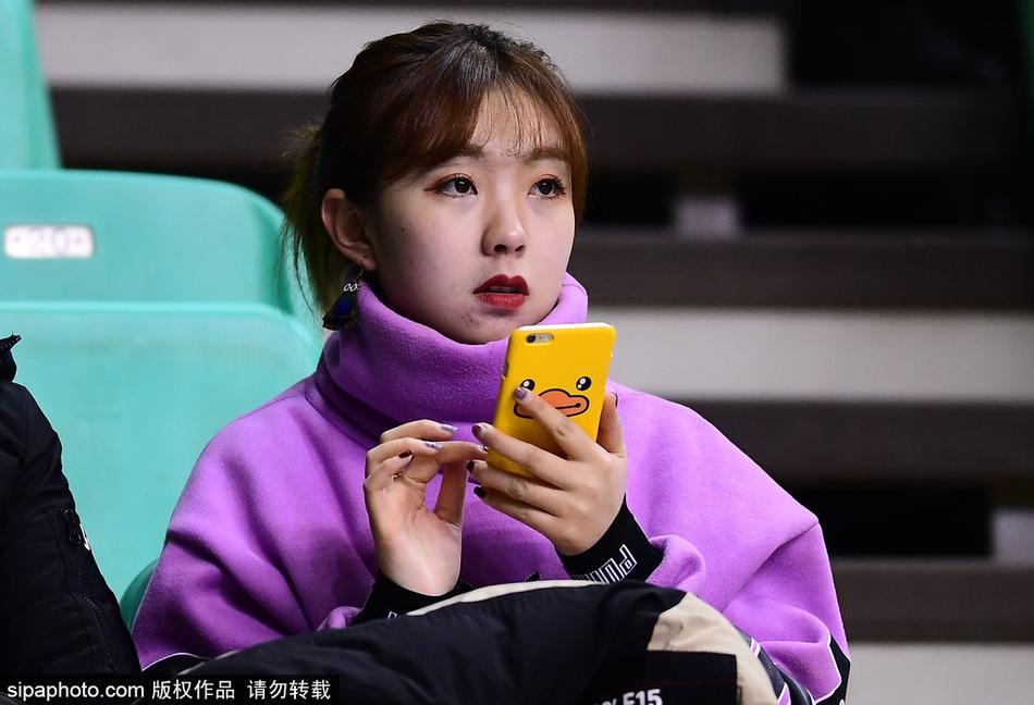 特写镜头下，这位美女球迷肌肤胜雪，她双手举着辽宁队的助威围巾，轻轻捂住口鼻，眉眼弯弯，笑意盈盈，仿佛在与场上奋战的球员进行无声的交流。