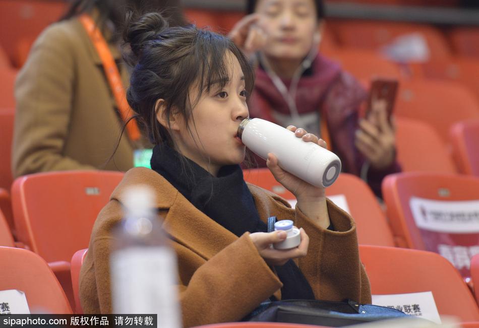 一位戴着眼镜的知性美女球迷,在人群中露出甜美的微笑,她或许是被比赛的某个精彩瞬间所打动,笑容里满是参与其中的快乐。