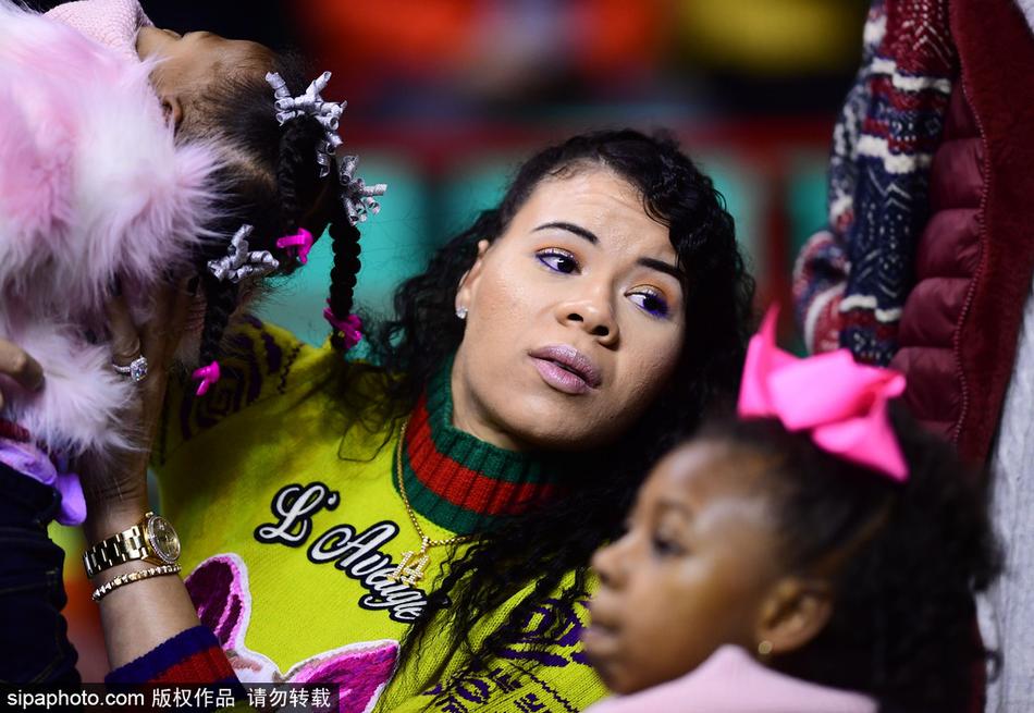 哈德森的小女儿在妈妈的怀抱中，好奇地望着球场上的爸爸，萌萌的表情惹人喜爱。