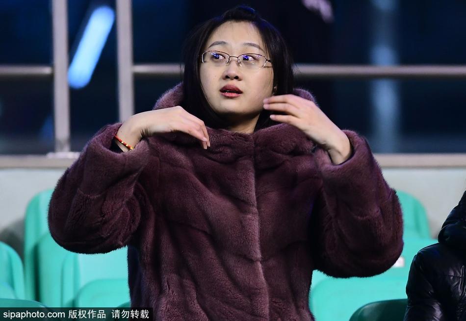 本溪体育馆入口处,一位身着棕色貂皮大衣的女球迷正在检票,她身后的背景是CBA联赛的巨幅海报,寒冷的空气中,她的身影显得格外引人注目,仿佛不是来看球,而是来参加一场冰雪中的时尚盛宴。