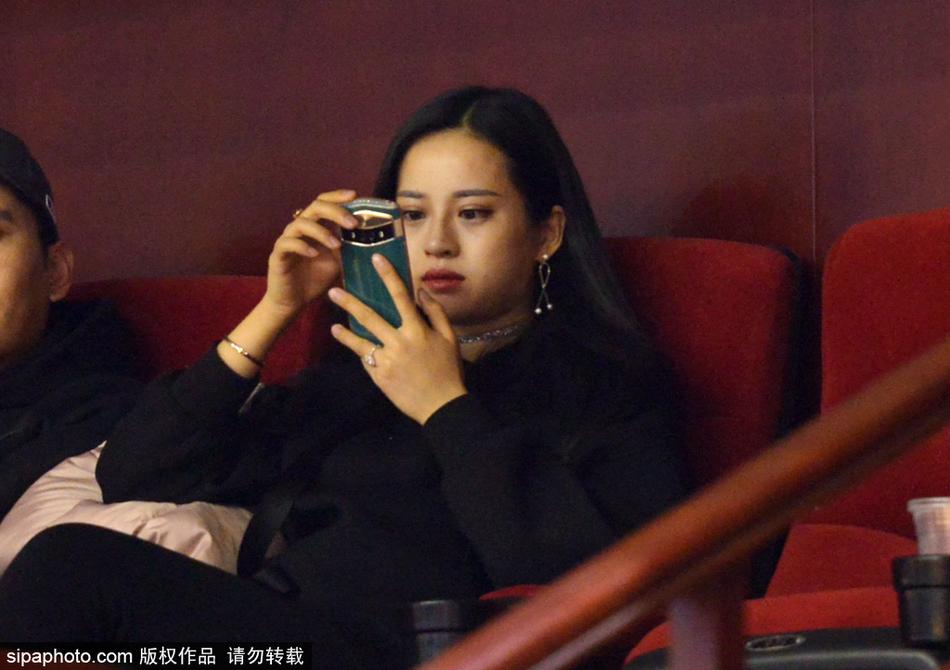 一位面容清秀的山东女球迷,身披深色外套,在全神贯注地观看比赛,她的眼神里充满了对主队获胜的渴望与期待。