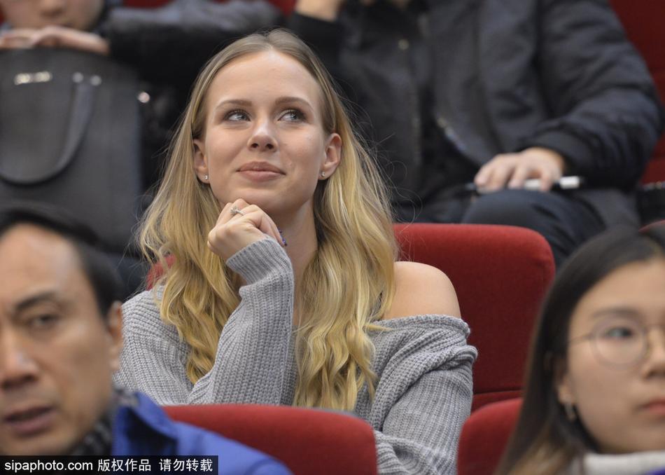 莫泰妻子在看台上专注地观看比赛,双手轻托脸颊,眼神紧紧追随着球场上丈夫的身影,满是关切与骄傲